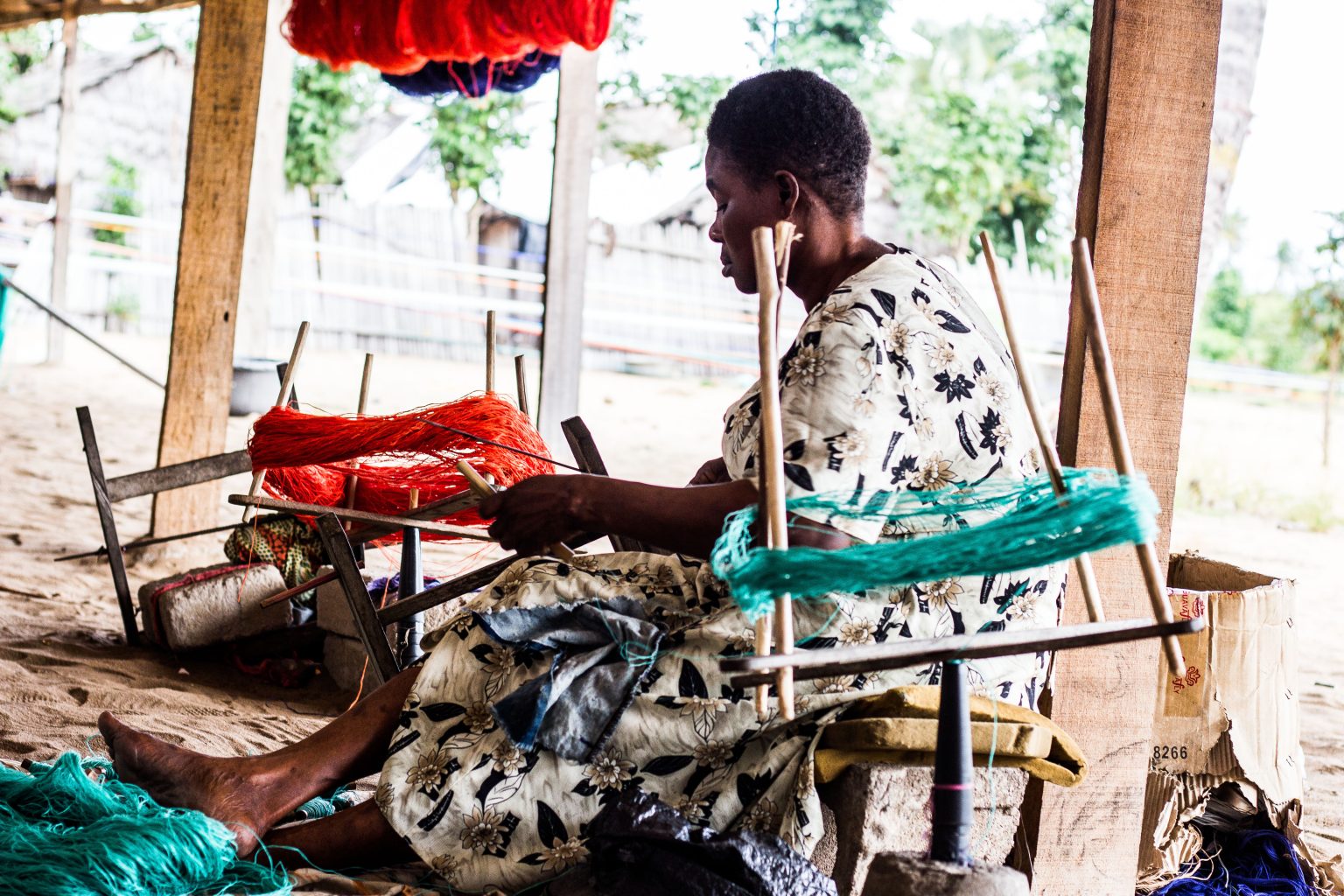 A craft practitioner working with colourful textile fibres